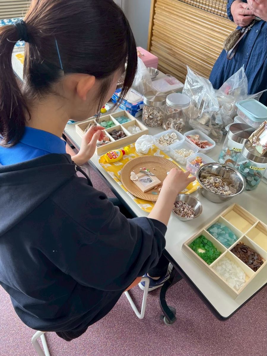 素材の入ったトレーから、使うかけらを選ぶ子ども
