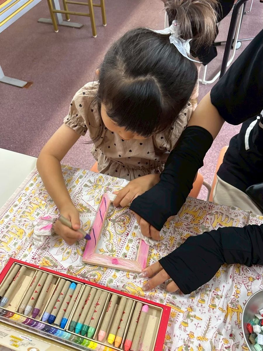 工作室でフレームに色をつけていく子ども