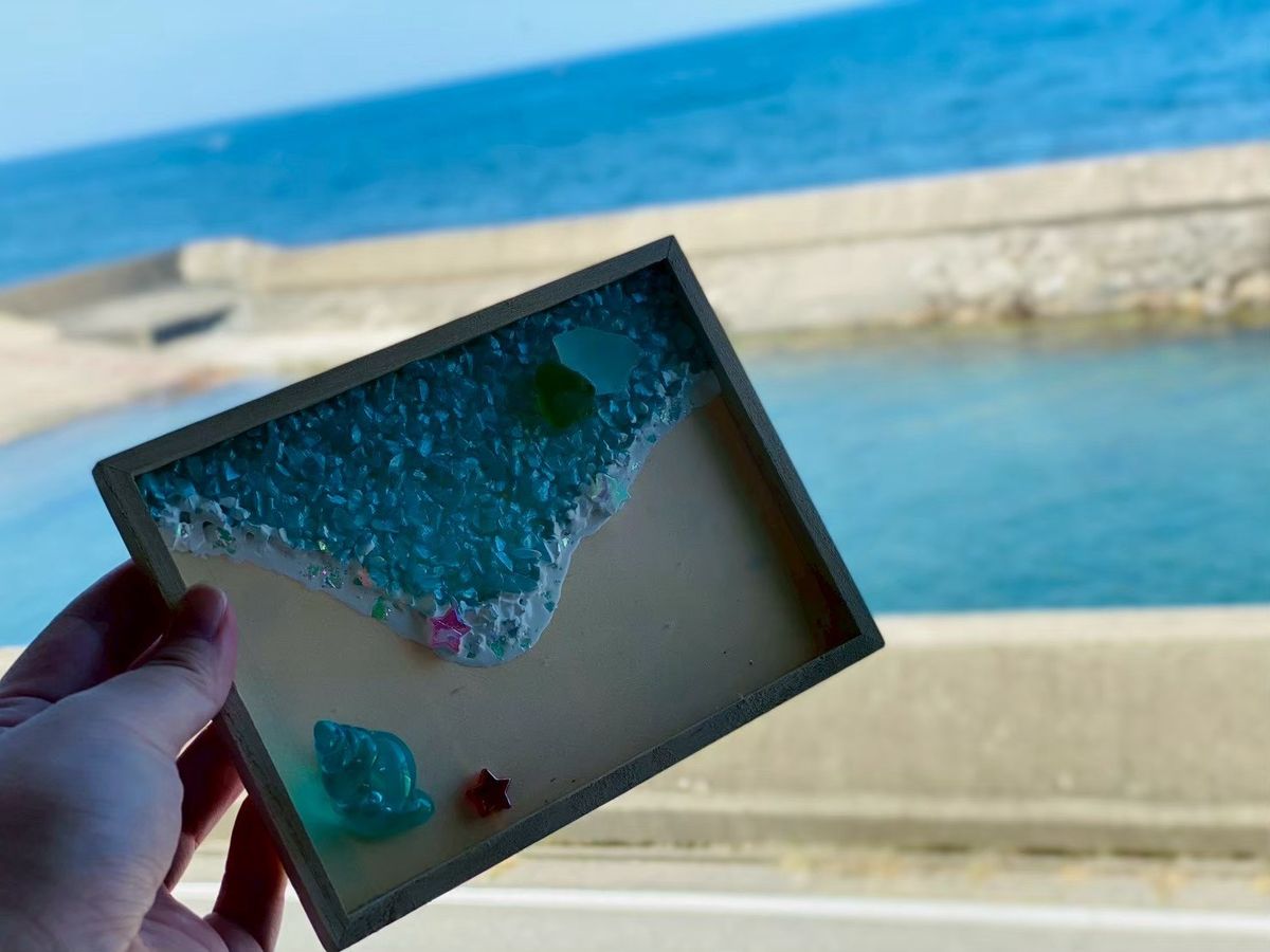 浜辺をかたどった作品と、その向こうに広がる日本海