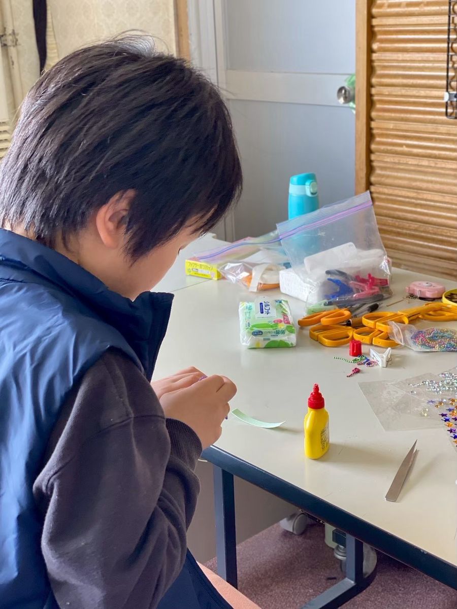 工作室のテーブルで制作に集中する子ども
